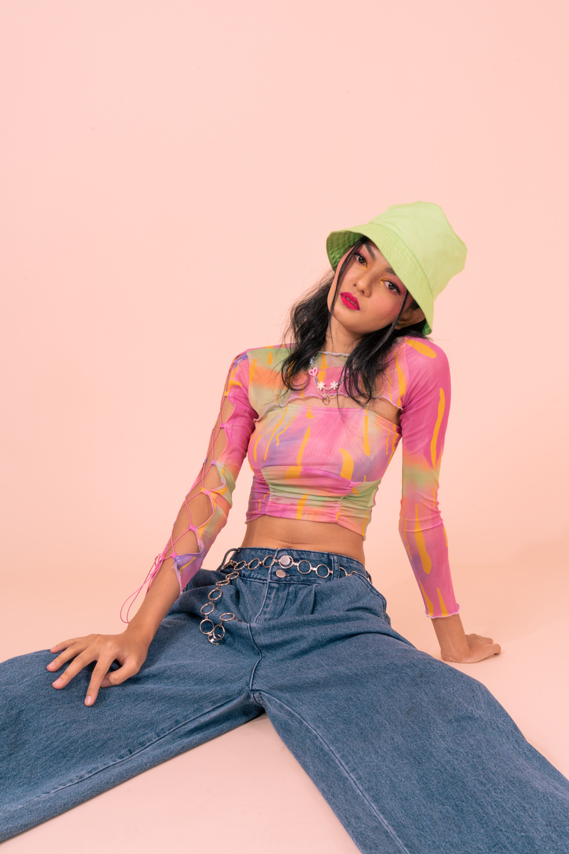 Sitting Woman in Bucket Hat, Crop Top and Jeans 