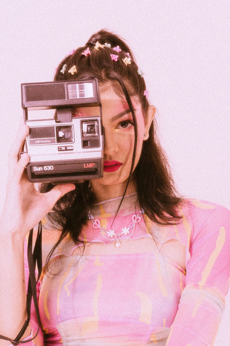 Young Woman with Vintage Camera in 90s Fashion
